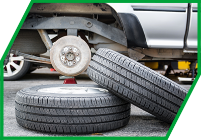 Zwei Reifen vor aufgebocktem Auto Bremse